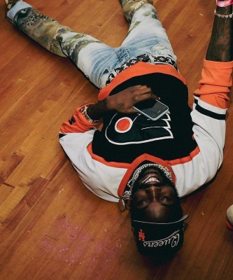 Meek Mill Wearing A Starter Flyers Jersey With A Louis Vuitton Belt And Amiri Jeans