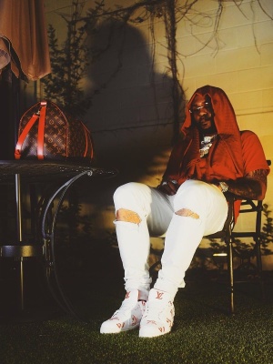 Moneyman Wearing A Louis Vuitton Red Scarf And Tee With White Jeans A Louis Vuitton Belt And Allover Logo Trainer Sneakers