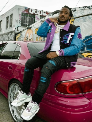Mozzy Wearing A Homme Femm Varsity Jacket Wiht Amiri Mx1 Jeans And Dior B22 Sneakers