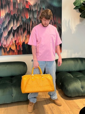 Murda Beatz Wearing A Bottega Veneta Pink Tshirt With Light Wash Jeans Nike Af1 Sneakers And A Yellow Goyard Bag