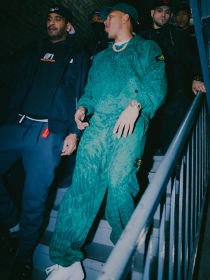 Myke Towers Wearing A Supreme X Stone Island Green Hat Hoodie And Sweatpants Outfit