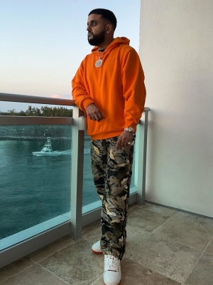 Nav Wearing A Marni Orange Outlined Logo Hoodie With Heron Preston Trackpants And New Balance 550 Sneakers