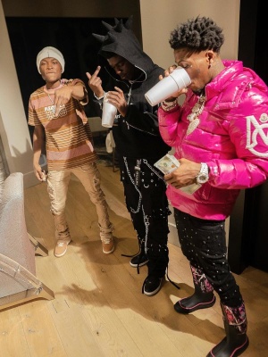 Nba Youngboy Wearing A Oncler Pink Puffer With Black Embellished Jeans And Pink Black Camo Boots