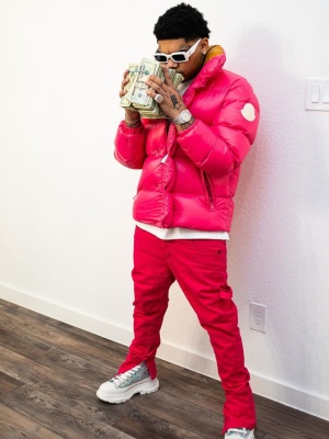 Nocap Wearing A Pink Moncler Puffer Jacket With Pink Jeans And Alexander Mcqueen Tread Slick Sneakers Boots