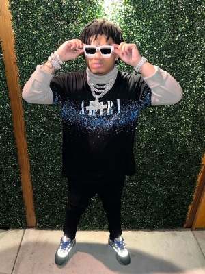 Nocap Wearing An Amiri Paint Splatter Tee With Louis Vuitton Sunglasses Black Jeans And Dior B22 Sneakers