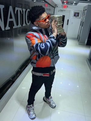 Nocap Wearing An Erl Sunset Puffer Jacket With A Christian Louboutin Silver Belt Black Jeans And Balenciaga Sneakers
