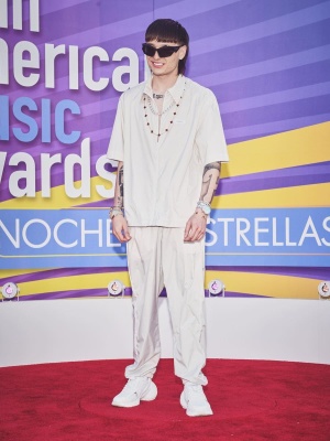 Peso Pluma At The Latin Music Awards In Givenchy Sunglasses With A Grey Shirt Trackpants And White Sneakers