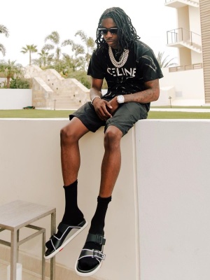 Polo G Wearing A Celine Black Tie Dye Tee With Louis Vuitton Sunglasses And Lv Trainer Sandals