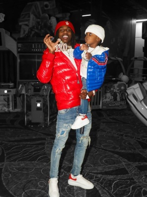 Polo G Wearing A Moncler Grenoble Beanie With A Moncler Red Puffer Jacket With Alexander Mcqueen Sneakers
