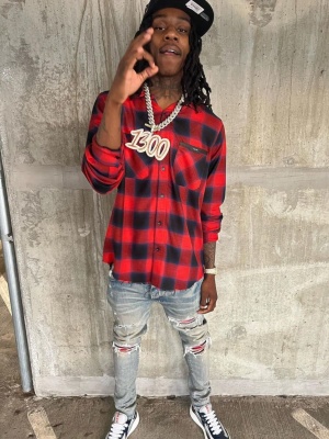 Polo G Wearing An Amiri Red Plaid Shirt With Red Plaid Jeans And Prada Black And Silver Americas Cup Sneakers