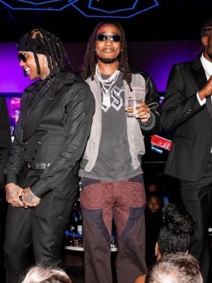 Quavo Wearing Black Sungalsses With A Grey Black Varsity Jacket And Patchwork Jeans