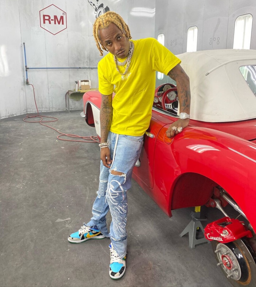 Rich The Kid In a Supreme Tee, Off-White Jeans, & Nike SBS Beside a Vintage Corvette
