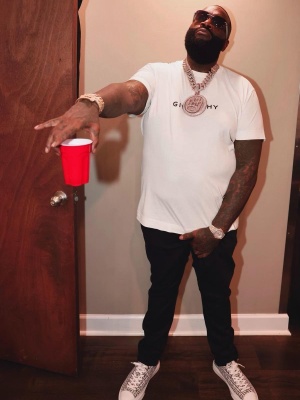Rick Ross Wearing A Givenchy White Reverse Logo Tee With Black Jeans And 4g Low Top City Sneakers
