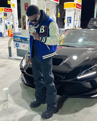 Roddy Ricch Wearing Louis Vuitton Sunglasses With A Burberry Varsity Jacket And Prada Boots
