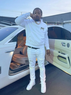 Rowdy Rebel Wearing An Amiri White 22 Hoodie And White Mx1 Jeans With A Louis Vuitton Belt And Nike Af1s