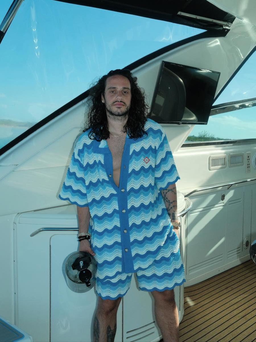 Russ Relaxes Topside In a Wavy Blue Crochet Shirt & Shorts Outfit