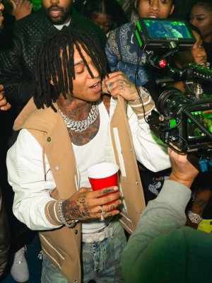 Swae Lee Wearing A Givenchy Varsity Jacket With A Ferragamo Belt And Printed Jeans