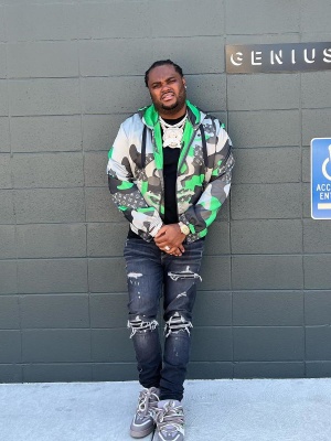 Tee Grizzley Wearing A Lv Patchwork Jacket And Sneakers With Amiri Jeans