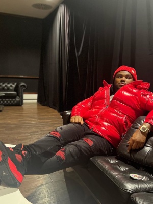 Tee Grizzley Wearing A Moncler Beanie And Red Maya Jacket With Amiri Black Suede Jeans Jordan Sneakers And An Audemars Piguet Watch