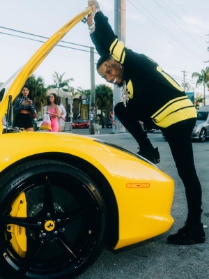 Tory Lanez Wearing A Louis Vuitton Black And Yellow Football Jersey With Black Jeans And Jordan 4s