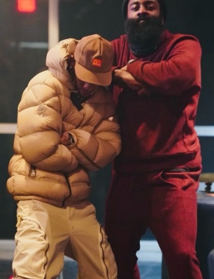 Travis Scott Wearing A Mcdonals Hat Moncler X Alyx Brown Puffer Jacket And Brown Cargo Pants