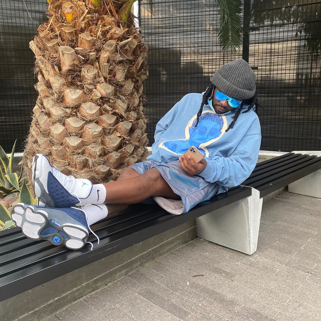 Wale Relaxes On a Park Bench In FoG Shorts & Matching Jordan 13s