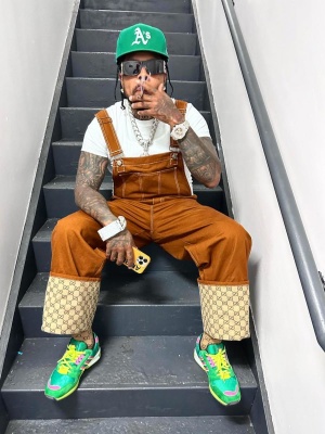 Westwide Gunn Wearing Gucci Overalls With Givenchy Sunglasses And Gucci X Adidas Sneakers
