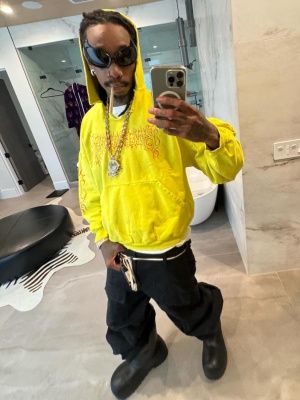 Wiz Khalifa Wearing A Balenciaga Gotham Cat Hoodie With A Yellow Logo Hoodie Black Baggy Cargo Pants And Black Boots