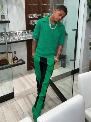 Yk Osiris Wearing A Bottega Veneta Green Knit Polo With Black And Green Panel Trackpants And Green Puddle Bomber Boots
