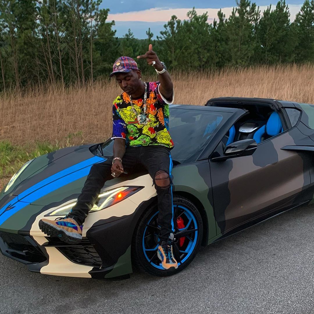 Dolph Promotes His Lambo Giveaway In a Gucci Hat & Tee, Amiri Jeans, & Nike Air Humaras